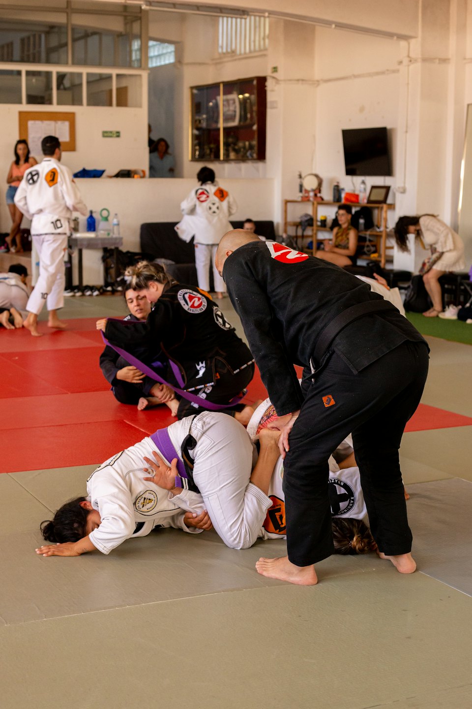 Estudiantes practican técnicas de Jiu-Jitsu brasileño sobre un tatami.